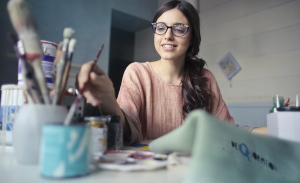 Women takes up painting as she straightens her teeth at home with invisible aligners