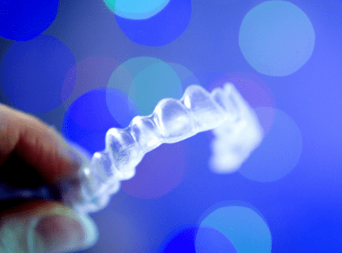 Woman inspects her at home teeth straightening aligners